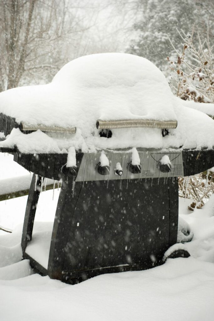 An outdoor grill covefred in snow.