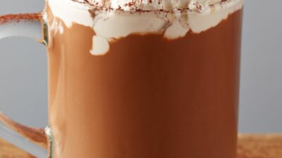 Tequila hot chocolate in a glass mug topped with whipped cream and cinnamon