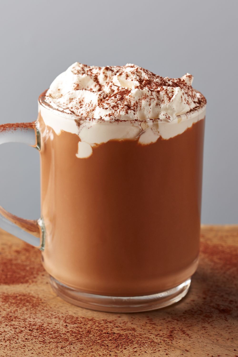 Tequila hot chocolate in a glass mug topped with whipped cream and cinnamon