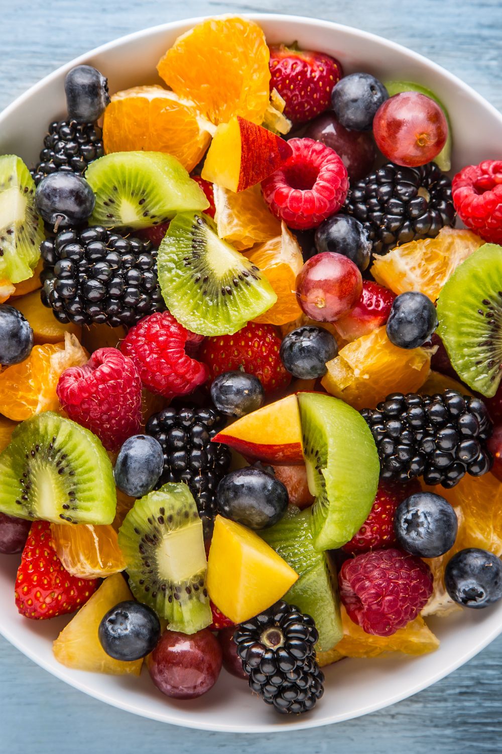 An overhead shot of berry fruit salad in a large white bowl