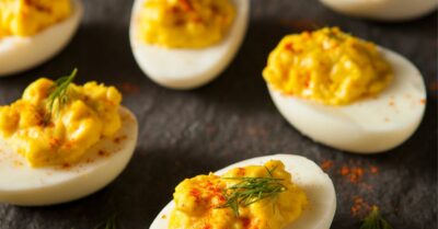 a slate platter topped with classic deviled eggs sprinkled with paprika