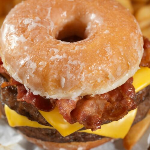 A photo of a doughnut bacon cheese burger with french fries
