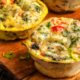 Healthy breakfast egg cups on a wooden cutting board.