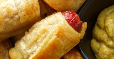pull apart pigs in a blanket in a pile with mustard next to it
