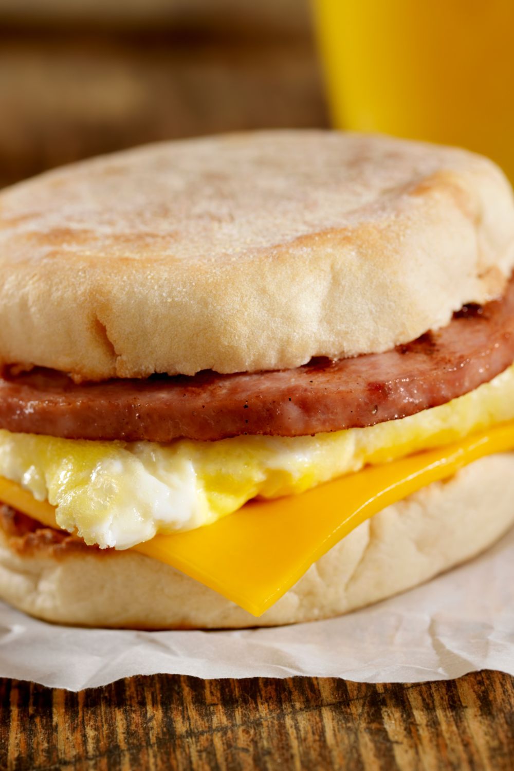 A simple egg sandwich on an english muffin with sausage and cheese