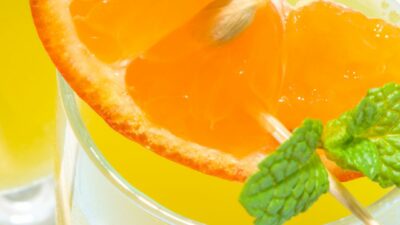 A March madness slam dunk cocktail with orange slices and mint in a glass