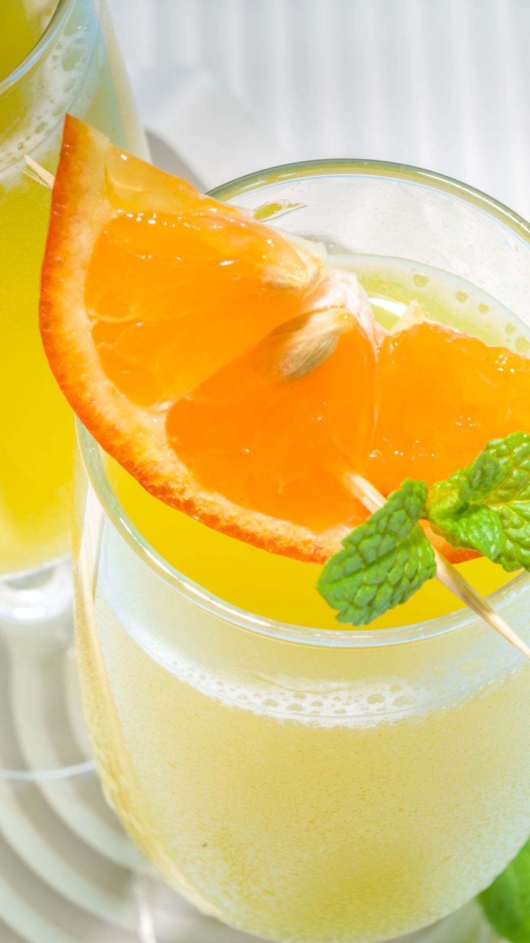 A March madness slam dunk cocktail with orange slices and mint in a glass