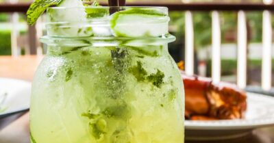 A cucumber tequila cocktail in a glass mason jar with cucumber slices in the jar