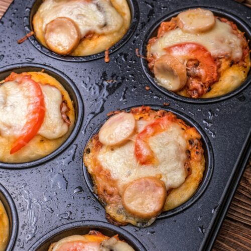 A muffin tin filled with cupcake pizzas