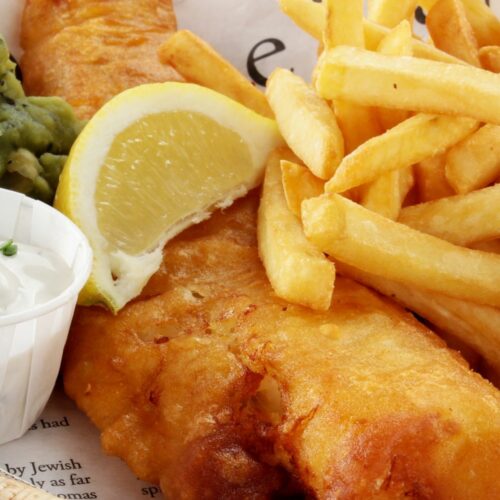 Fried British fish and chips with a lemon slice over the top