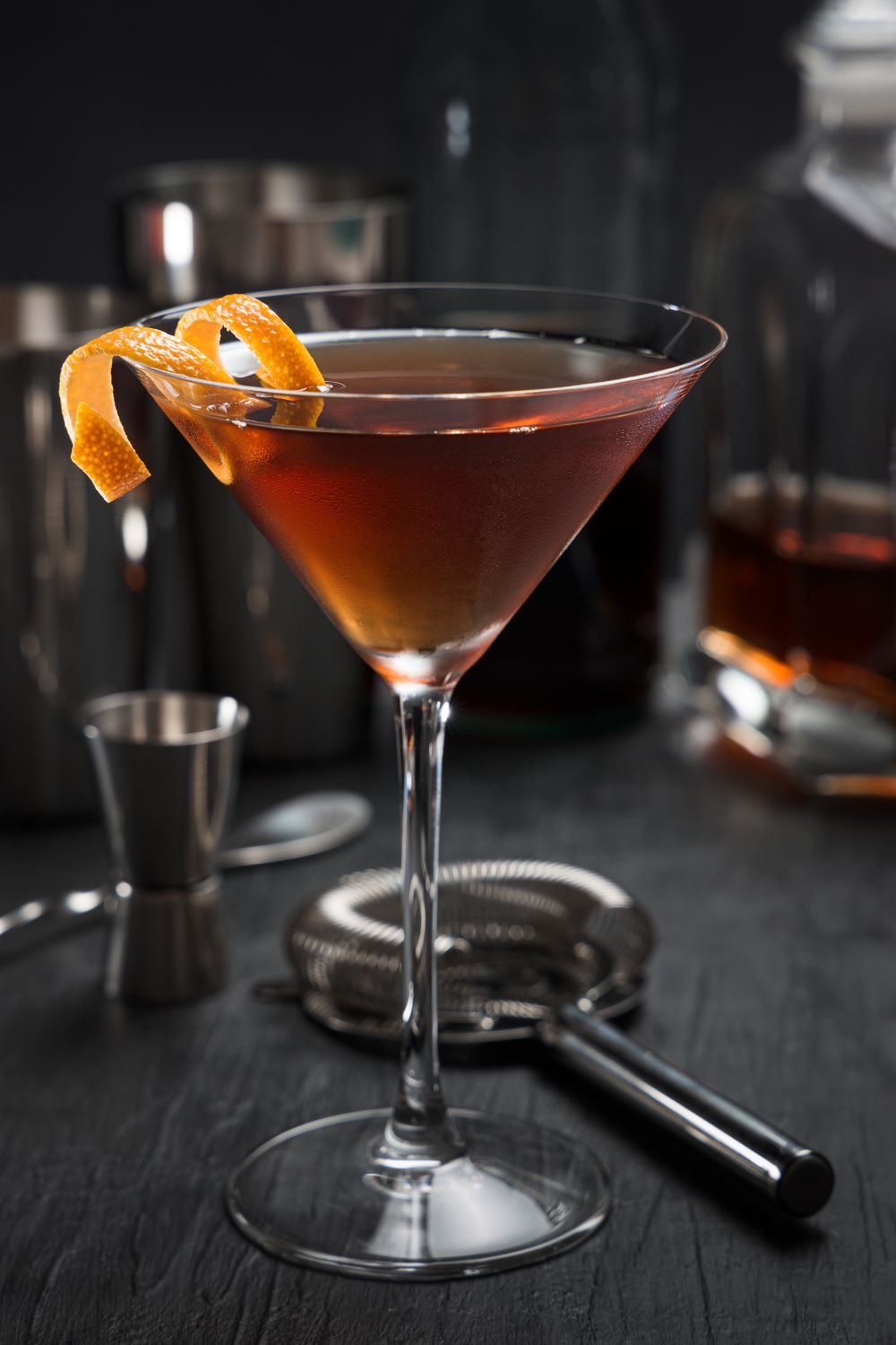 A Pimm's cup cocktail in a martini glass with an orange twist