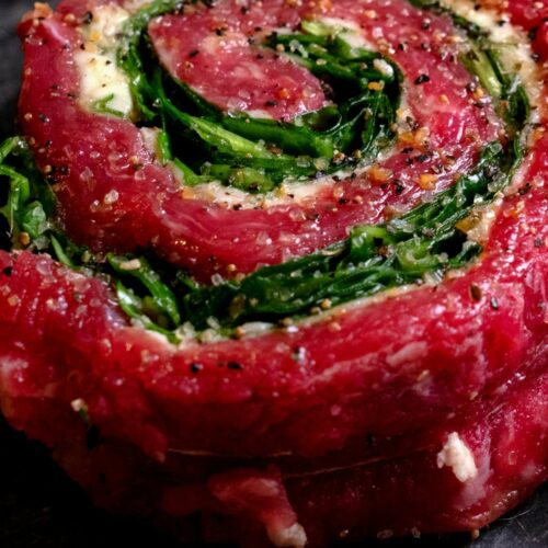 A skirt steak wrapped in a pinwheel stuffed with greens