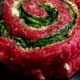 A skirt steak wrapped in a pinwheel stuffed with greens