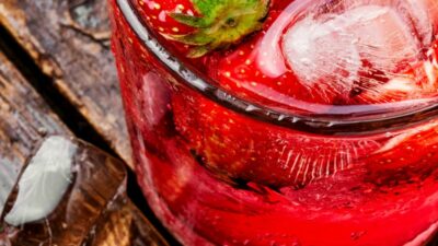 A southern sweet tea jam drink in a glass garnished with strawberries