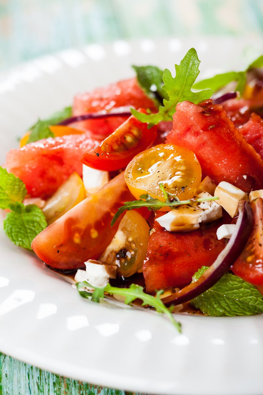 An heirloom tomato and watermelon salad in a white plate