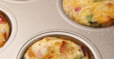 a muffin tin with grilled eggs in it