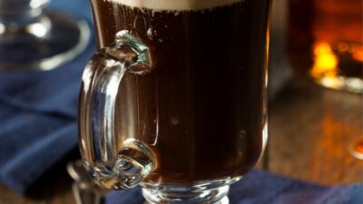 A kentucky coffee drink in a glass mug topped with whipped cream.