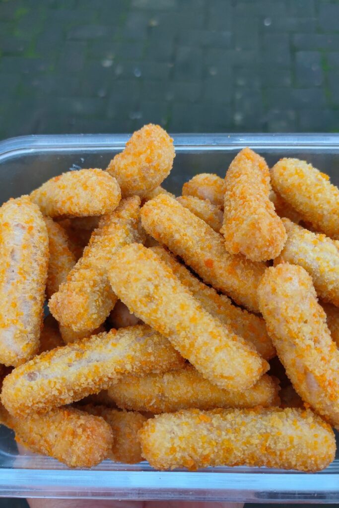 A bunch of breaded chicken fries in an air fryer basket.