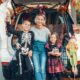 A mother and her son and daughter sitting in a car decorated for a trunk or treat halloween tailgate.