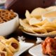 A bunch of appetizers on a table with a football in the background.