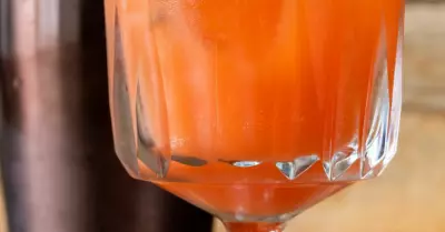 A belmont breeze cocktail in a glass with a shaker behind it