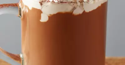 Tequila hot chocolate in a glass mug topped with whipped cream and cinnamon