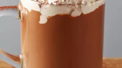 Tequila hot chocolate in a glass mug topped with whipped cream and cinnamon