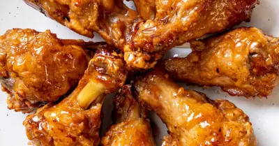 A circle of apple butter brown sugar wings on a white plate