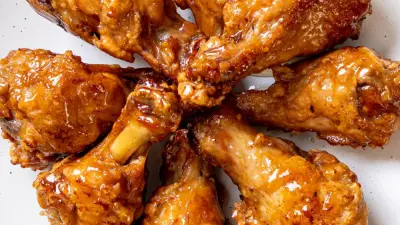 A circle of apple butter brown sugar wings on a white plate