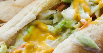 A hotdog in a bun topped with coleslaw and jalapenos