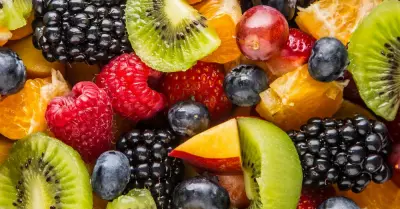An overhead shot of berry fruit salad in a large white bowl