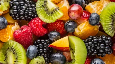 An overhead shot of berry fruit salad in a large white bowl