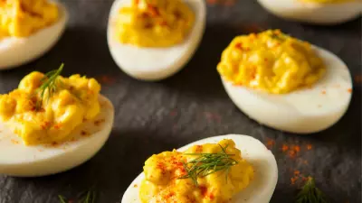 a slate platter topped with classic deviled eggs sprinkled with paprika