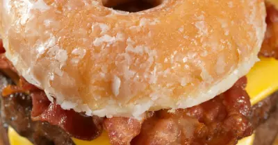 A photo of a doughnut bacon cheese burger with french fries