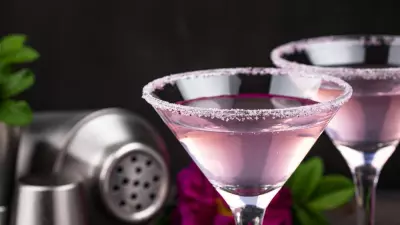 A light purple eagle cocktail in a martini glass with a black background