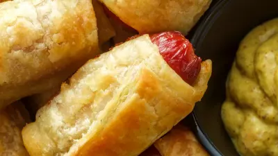 pull apart pigs in a blanket in a pile with mustard next to it