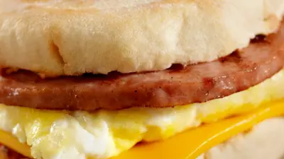 A simple egg sandwich on an english muffin with sausage and cheese