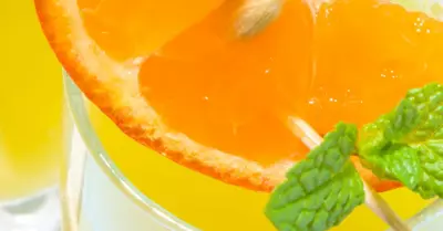 A March madness slam dunk cocktail with orange slices and mint in a glass
