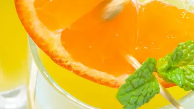 A March madness slam dunk cocktail with orange slices and mint in a glass