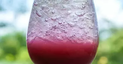A transfusion cocktail inside of a glass with the grape juice on the bottom and ginger beer on top