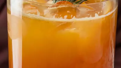 An azalia cocktail in a glass with rosemary on top