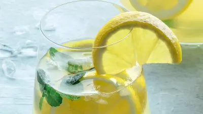 Coconut lemon punch in a glass garnished with lemon slices and mint