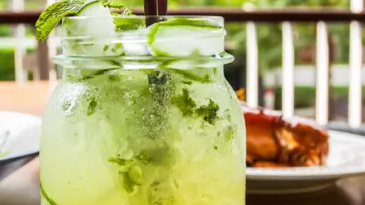 A cucumber tequila cocktail in a glass mason jar with cucumber slices in the jar
