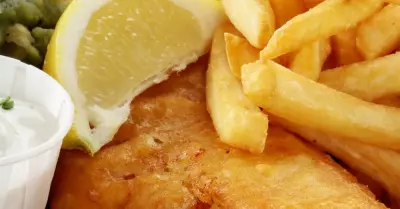 Fried British fish and chips with a lemon slice over the top