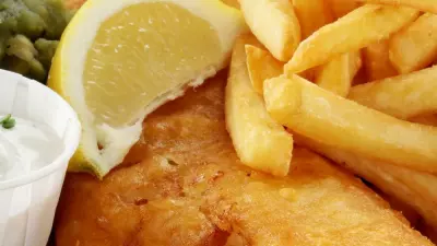 Fried British fish and chips with a lemon slice over the top