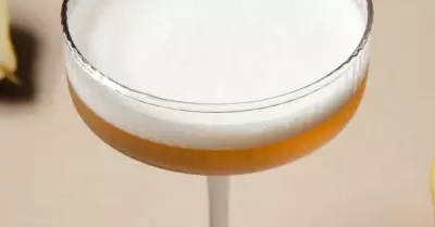 A green derby drink in a coup glass with foam on top