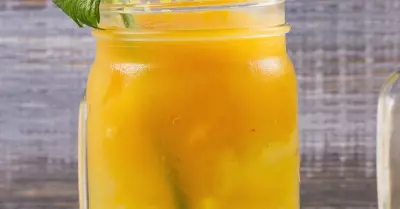 A mango mary cocktail in a glass with a celery stick