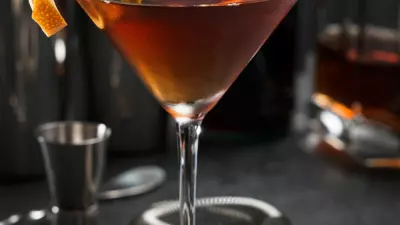 A Pimm's cup cocktail in a martini glass with an orange twist