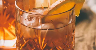 A preakness cocktail in a glass with a slice of orange in the glass