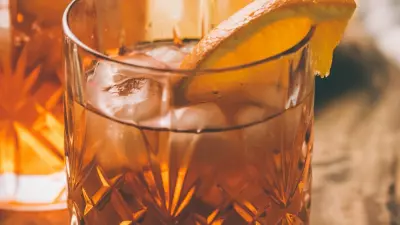 A preakness cocktail in a glass with a slice of orange in the glass